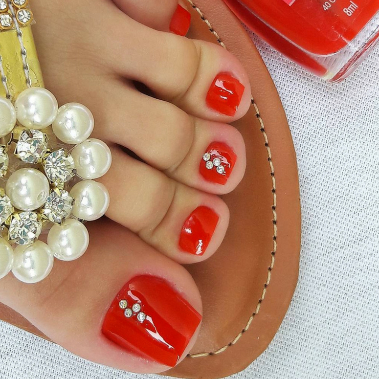 unha do pe vermelha decorada com strass no dedao