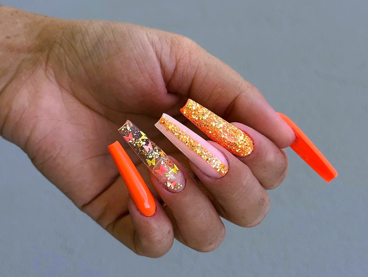 unha laranja com filha única de glitter