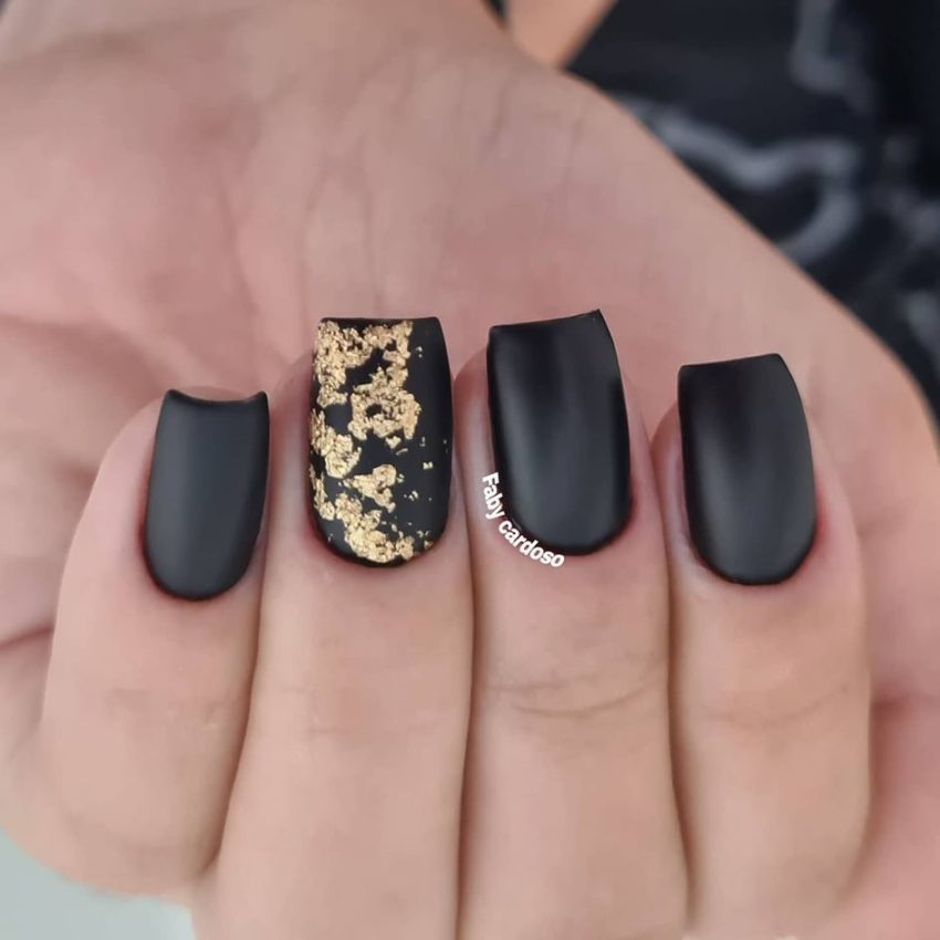 unha preta fosca com folha de ouro