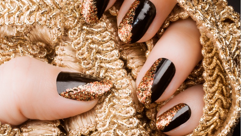 unha preta com glitter dourado
