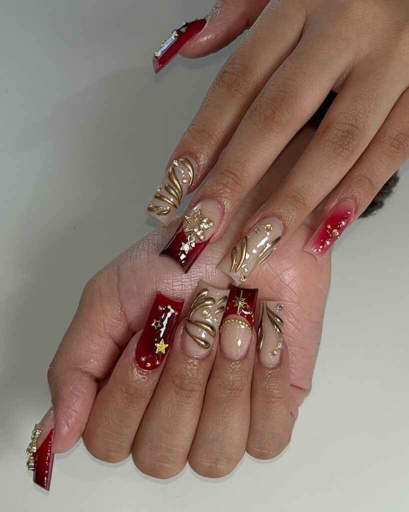 Unhas vermelhas com pedrarias douradas