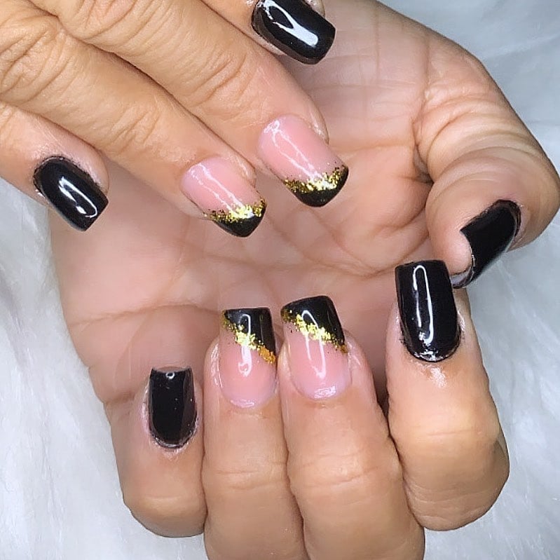 unha preta com detalhes em ouro